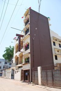 um edifício alto com uma cerca em frente em Hotel Natraj em Ranchi