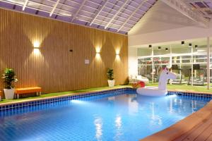 uma piscina com um unicórnio flutuante num edifício em Grand Hill Resort and Spa em Nakhon Sawan