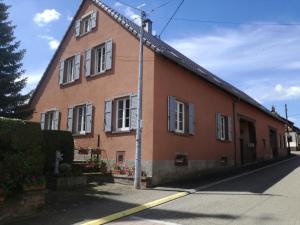 a brown building with white windows on a street at LE TOMIGITE in Dimbsthal