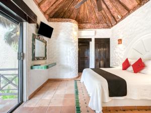 1 dormitorio con 1 cama y TV en la pared en Capital O Mimi Del Mar, Playa del Carmen en Playa del Carmen