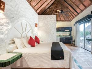 a bedroom with a large bed with red pillows at Capital O Mimi Del Mar, Playa del Carmen in Playa del Carmen