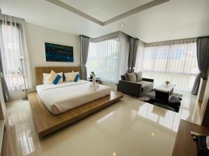 a bedroom with a large bed and a living room at Buasri By Ohm in Patong Beach