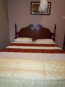 a bedroom with a large bed with white sheets at KERESI BLOCK At PENIEL BEACH HOTEL in Entebbe