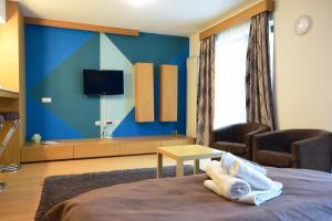 a room with a bed with a blue wall at Decebal Residence Apartments in Bucharest