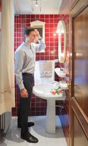 a man standing in a bathroom with a sink at Villa Rossana in Cenaia