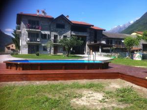 ein Gebäude mit einem Pool vor einem Haus in der Unterkunft Casa Vacanze Zia Vivina in Sorico