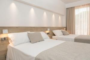 a hotel room with two beds and a window at RVHotels Nieves Mar in L'Escala