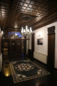 a lobby with a chandelier and a large rug at Cheltikov Hotel in Kars