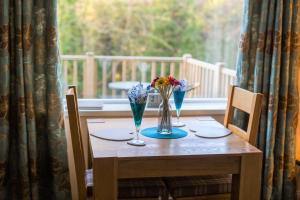 ein Tisch mit zwei Stühlen und ein Tisch mit Blumen darauf in der Unterkunft Host & Stay - Daisy Cottage in Bamburgh