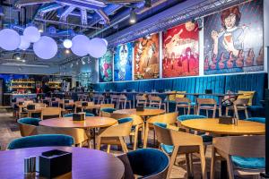 a restaurant with wooden tables and blue chairs at Comfort Hotel LT - Rock 'n' Roll Vilnius in Vilnius