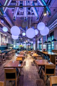 a dining room with tables and chairs and lights at Comfort Hotel LT - Rock 'n' Roll Vilnius in Vilnius