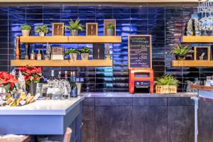 a restaurant with a counter with plants on the wall at Comfort Hotel LT - Rock 'n' Roll Vilnius in Vilnius