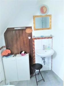 a bathroom with a sink and a mirror and a stool at marielies-urlaubsstube in Meißenheim