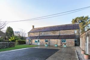 ein altes Steingebäude mit einer Einfahrt davor in der Unterkunft Host & Stay - Daisy Cottage in Bamburgh