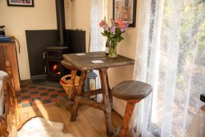 a wooden table with a vase of flowers on it at Finest Retreats - The Tree House - Eco-Friendly, Back to Nature Experience in Germansweek