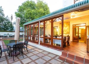 un patio al aire libre con mesa y sillas en Evergreen Lodge, en Stellenbosch