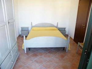 una piccola camera da letto con un letto con una coperta gialla di Terrazze sul Mare alla Ciaccia - Apartment 4 a Codaruina
