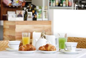 a table with croissants and glasses of orange juice at Domus Pacis Assisi in Assisi