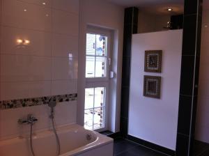 bagno con vasca, servizi igienici e finestra di Haus Strandlaeufer a Dranske