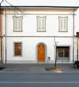 a white building with a wooden door on a street at Villa Anna in Torre del Lago Puccini