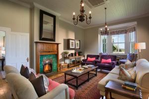 a living room with couches and a fireplace at Kwandwe Uplands Homestead in Grahamstown