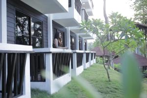 a woman sitting on a balcony of a building at Aman Dan Laut in Perhentian Island