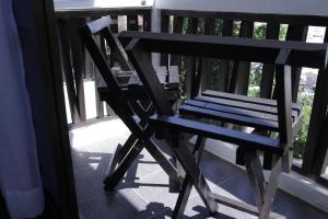 a wooden bench sitting on a porch with a table at Aman Dan Laut in Perhentian Islands