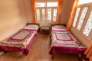 A bed or beds in a room at New Tourist Guest House