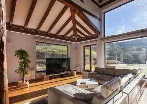 a large living room with a couch and a tv at Excepcional chalet cerca de Cabárceno in Pámanes