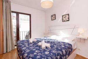 a bedroom with a blue and white bed and a window at Canovas Nerja - Balcón de Europa in Nerja