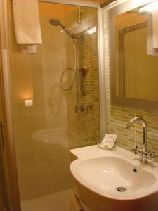 a bathroom with a shower, sink, and mirror at La Maison Des Rêves in Syracuse