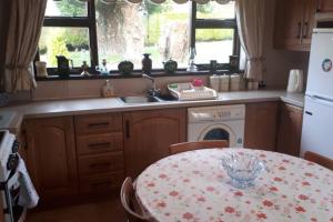 a kitchen with a table and a sink and a stove at Bessies Cottage in Ahoghill