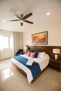 1 dormitorio con 1 cama grande y ventilador de techo en Petit Luxe Las Gavias Penthouse, en Mazatlán