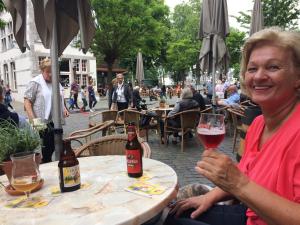 uma mulher sentada à mesa com um copo de vinho em Belle Vue Vakantieappartement em Genoelselderen