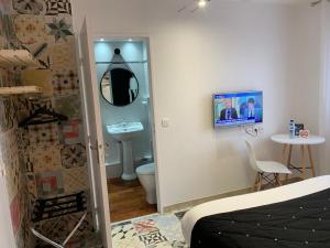 a bathroom with a sink and a toilet and a mirror at Hotel Restaurant Baryton in Saint-Marcel