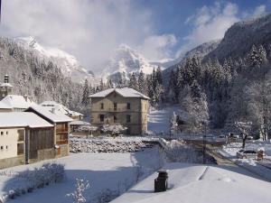 ein Haus im Schnee mit einem Berg im Hintergrund in der Unterkunft Le Bivouac in Sixt