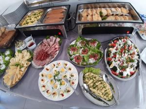 una mesa con muchos tipos diferentes de comida en ella en Villa Prusa - pensjonat Mielno en Mielno