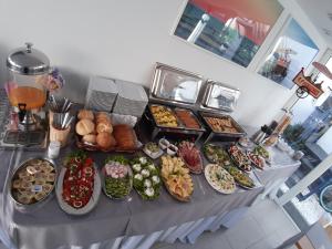 una mesa cubierta con muchos tipos diferentes de comida en Villa Prusa - pensjonat Mielno en Mielno