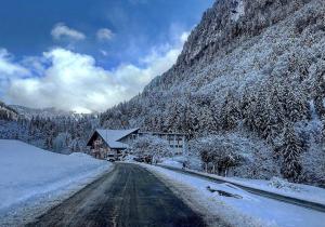 ein Haus auf einer schneebedeckten Straße neben einem Berg in der Unterkunft Non in Montriond