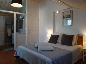 una camera da letto con un grande letto con una coperta blu di appartements d'hôtes La Foulonnerie a Mios