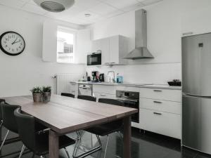 uma cozinha com uma mesa de madeira e um relógio na parede em Gamla Televerket B&B em Borgholm
