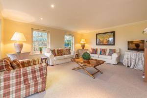 a living room with couches and a table at Higham Place Lodge in Higham