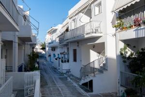 an alley in a town with white buildings at Downtown Apartment in Parikia