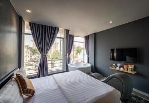 a bedroom with a bed and a window with a sink at Bonita Boutique Hotel in Ho Chi Minh City