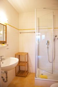 uma casa de banho com um lavatório e um chuveiro em Hotel Alpenglühn em Füssen