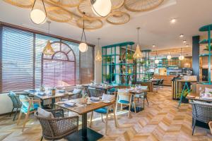 a restaurant with tables and chairs and bookshelves at Occidental Fuengirola in Fuengirola