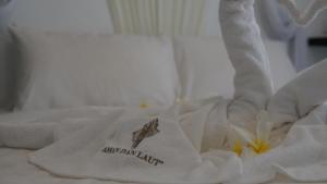 Una toalla en una cama con una flor. en Aman Dan Laut en Perhentian Island