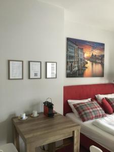 a room with a bed and a table and a painting at Premium Apartment München Messe in Munich