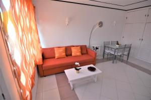 un soggiorno con divano rosso e tavolo di Apartamento Bello Atardecer a Tacoronte