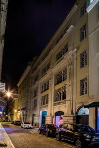 a building with cars parked in front of it at night at Stay Hotel Lisboa Centro Chiado in Lisbon